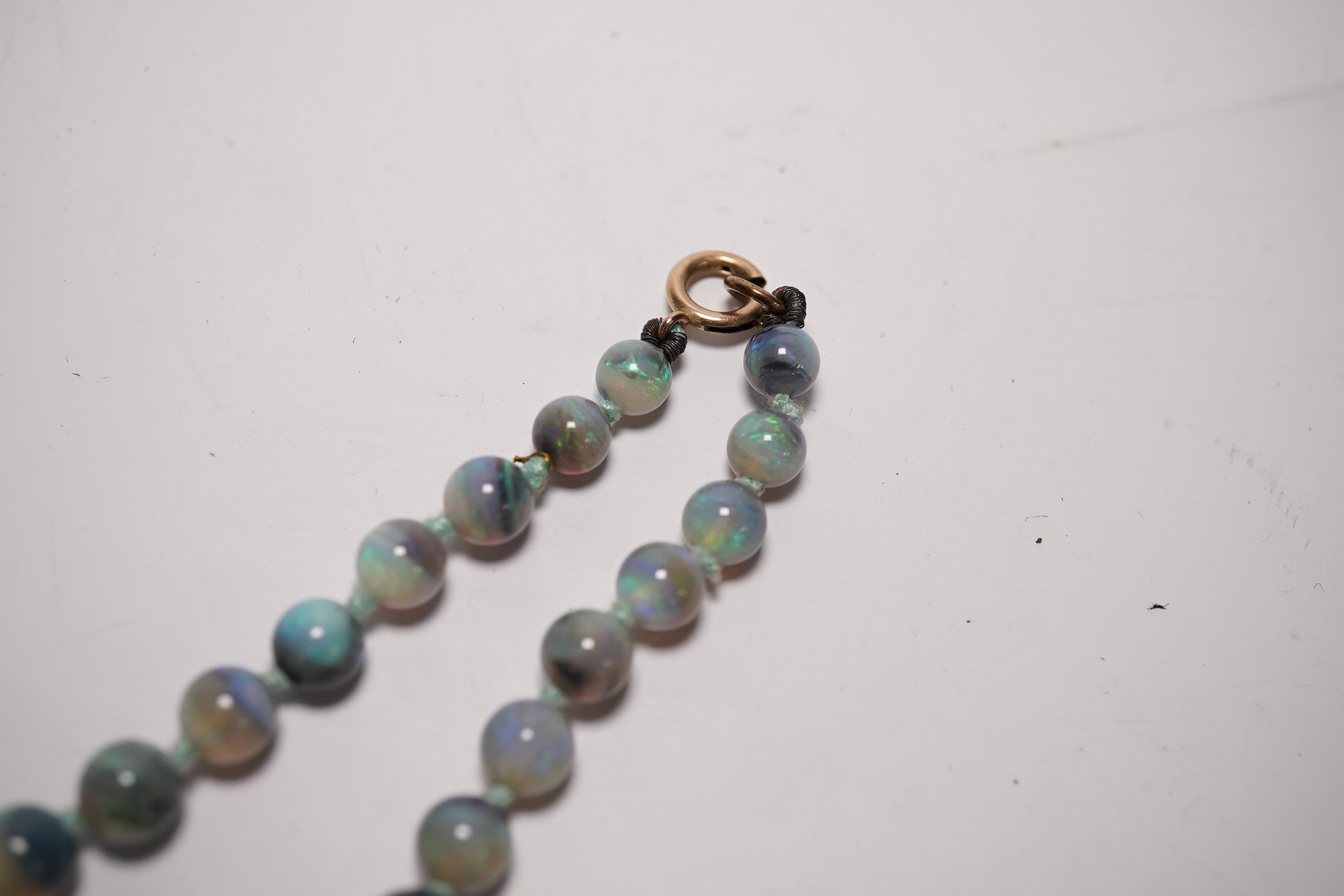 A single strand graduated blue opal bead necklace, with 9ct clasp, retailed by Liberty & Co?, 44cm, with Liberty & Co box. Condition - fair to good